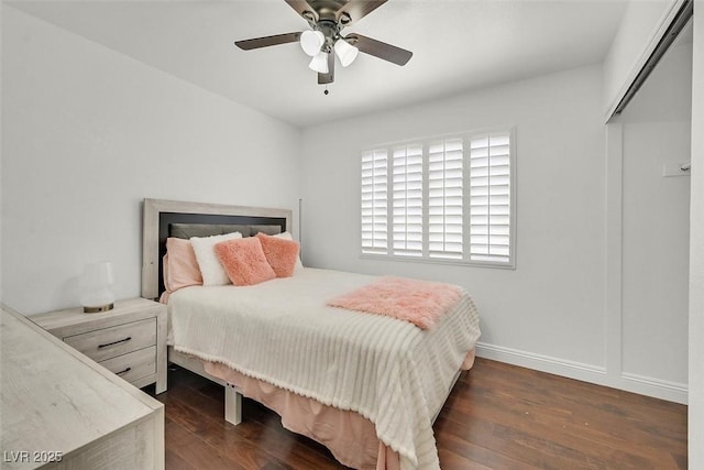 bedroom with ceiling fan, dark wood-style flooring, and baseboards