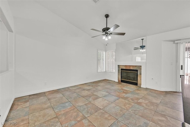 unfurnished living room with a healthy amount of sunlight, ceiling fan, a fireplace, and vaulted ceiling