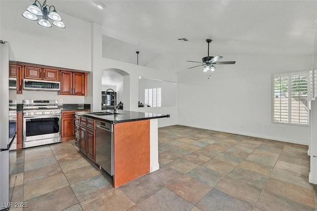 kitchen featuring appliances with stainless steel finishes, dark countertops, a sink, and plenty of natural light