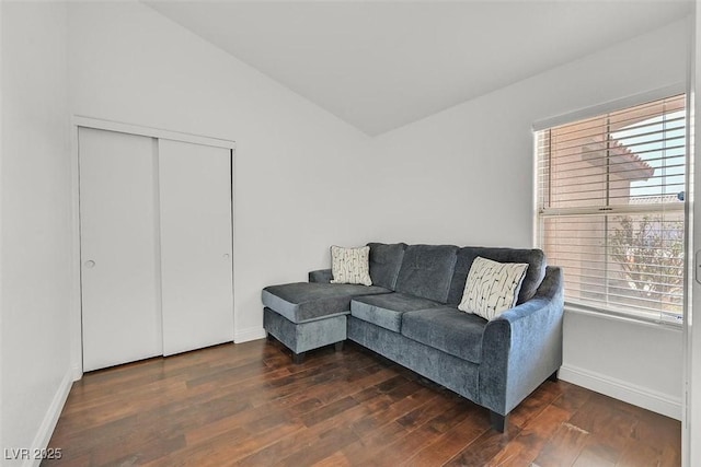 living area with vaulted ceiling, dark wood-style flooring, and baseboards