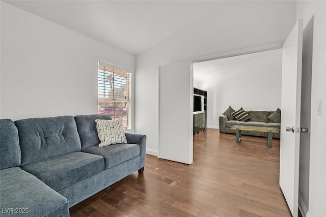 living room with vaulted ceiling, baseboards, and wood finished floors