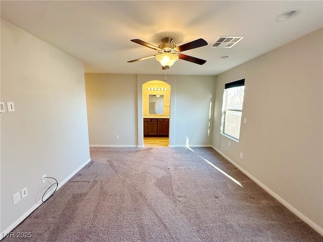 spare room featuring ceiling fan, light colored carpet, visible vents, and baseboards