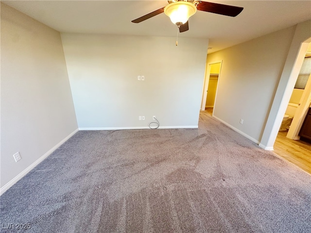 empty room with ceiling fan, baseboards, and light colored carpet