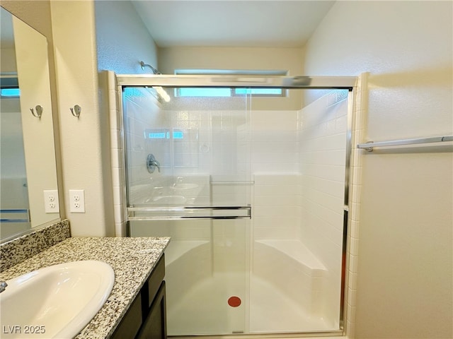 full bathroom with a shower stall and vanity