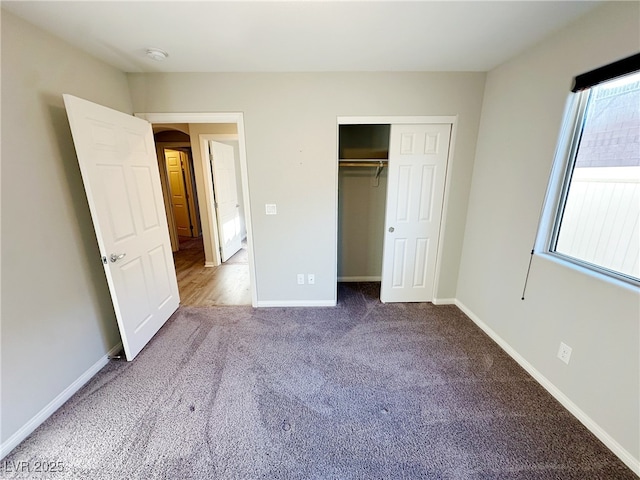 unfurnished bedroom featuring a closet, carpet, and baseboards