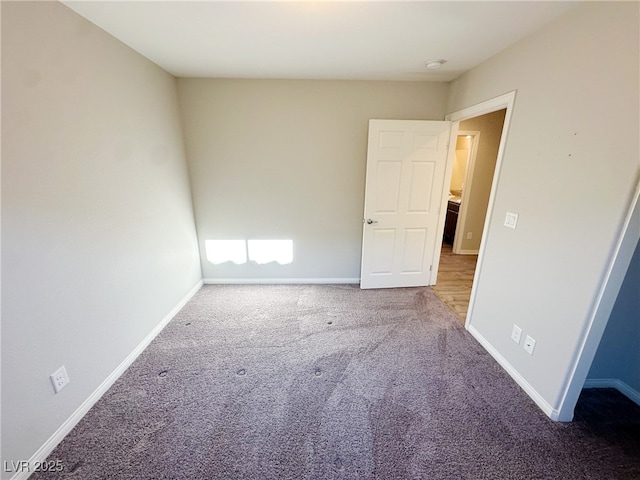 carpeted empty room featuring baseboards