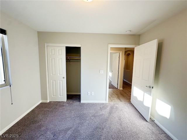 unfurnished bedroom featuring a closet, light carpet, and baseboards