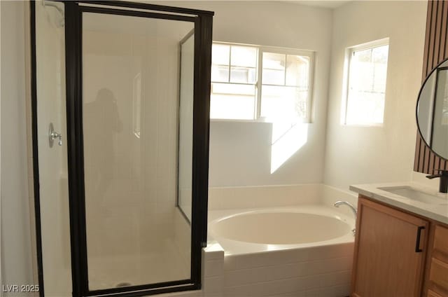 bathroom featuring a stall shower, a garden tub, and vanity