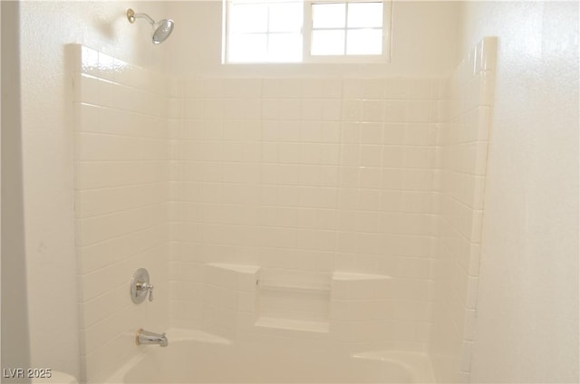 interior details featuring washtub / shower combination