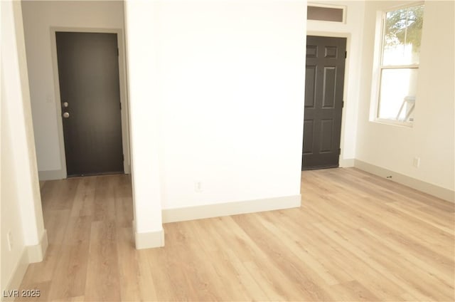 unfurnished room with light wood-style flooring and baseboards