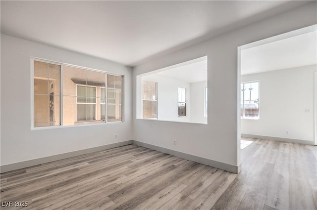 empty room featuring wood finished floors and baseboards