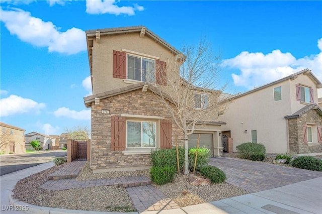 view of front of house with stone siding, decorative driveway, and stucco siding