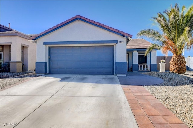 view of front of home with a garage, a tile roof, concrete driveway, and stucco siding