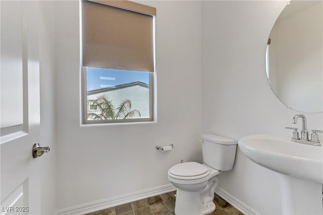 bathroom featuring a sink, toilet, and baseboards