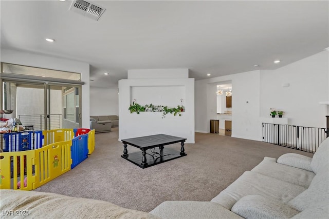 living room featuring an inviting chandelier, recessed lighting, visible vents, and light colored carpet