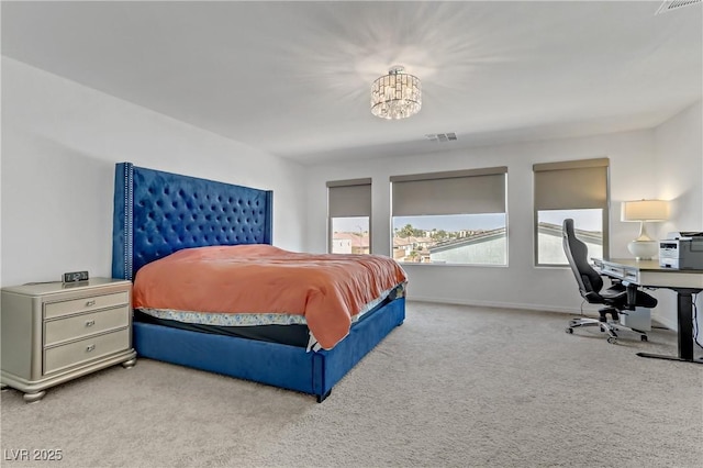 carpeted bedroom featuring baseboards, visible vents, and a chandelier