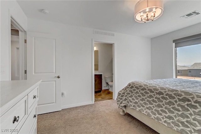 bedroom with light colored carpet, visible vents, connected bathroom, and an inviting chandelier