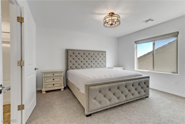 bedroom with baseboards, visible vents, and light colored carpet