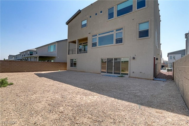 back of house featuring fence and stucco siding