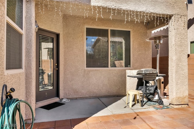 entrance to property featuring a patio and stucco siding