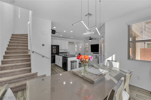 dining space featuring light wood-style floors, stairs, wine cooler, and visible vents