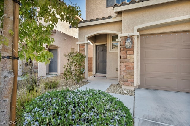 doorway to property featuring stone siding, a tiled roof, and stucco siding