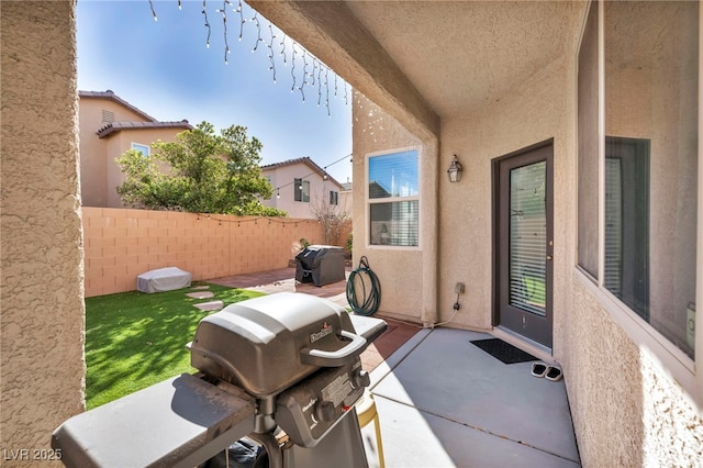 view of patio featuring a grill and fence