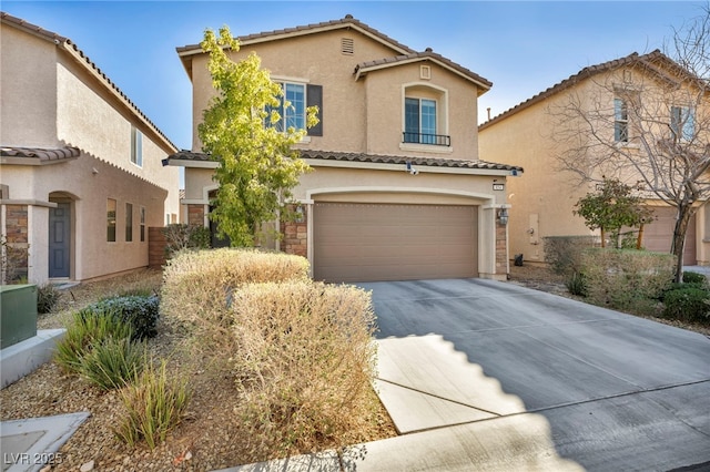 mediterranean / spanish-style house with driveway, a tiled roof, an attached garage, and stucco siding