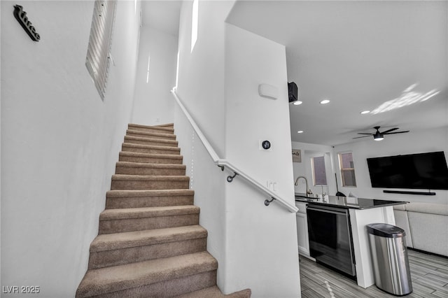 stairs with recessed lighting, ceiling fan, and wood finished floors