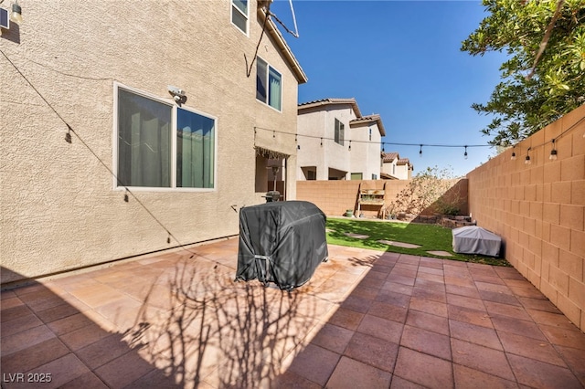 view of patio featuring a fenced backyard and a grill