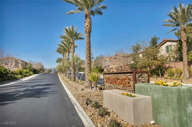 view of road featuring curbs, a gated entry, and a residential view