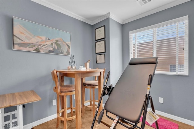 dining area featuring visible vents, baseboards, wood finished floors, and crown molding