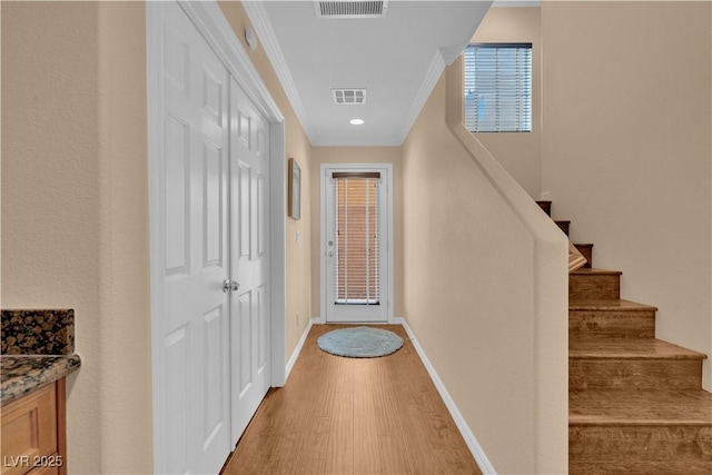 entryway featuring light wood-type flooring, visible vents, baseboards, and stairs