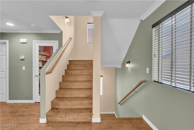 staircase with plenty of natural light, baseboards, and crown molding