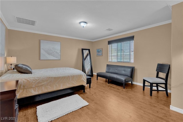 bedroom featuring visible vents, baseboards, ornamental molding, and wood finished floors