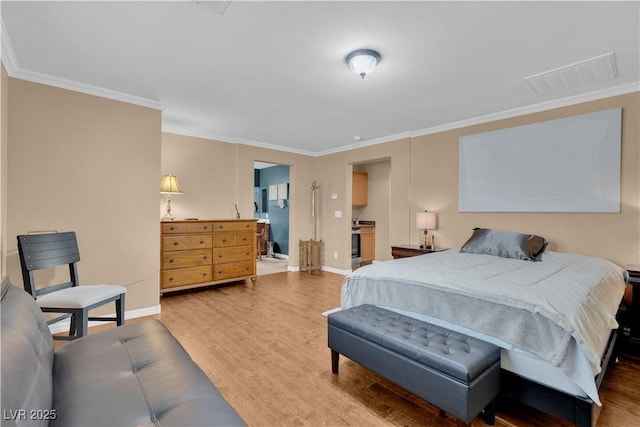 bedroom with visible vents, crown molding, baseboards, and wood finished floors