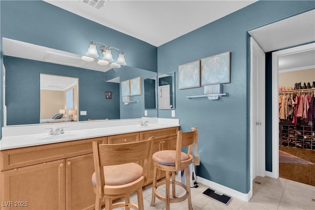 bathroom featuring a sink, visible vents, double vanity, and tile patterned flooring