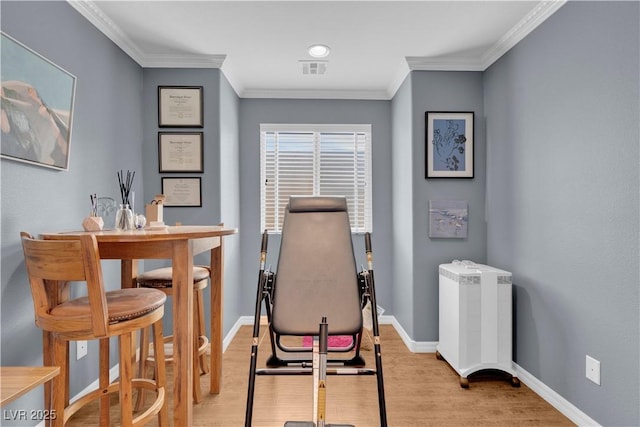 office area featuring visible vents, baseboards, wood finished floors, and crown molding