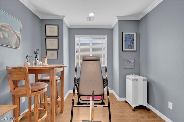 interior space with visible vents, baseboards, ornamental molding, and wood finished floors