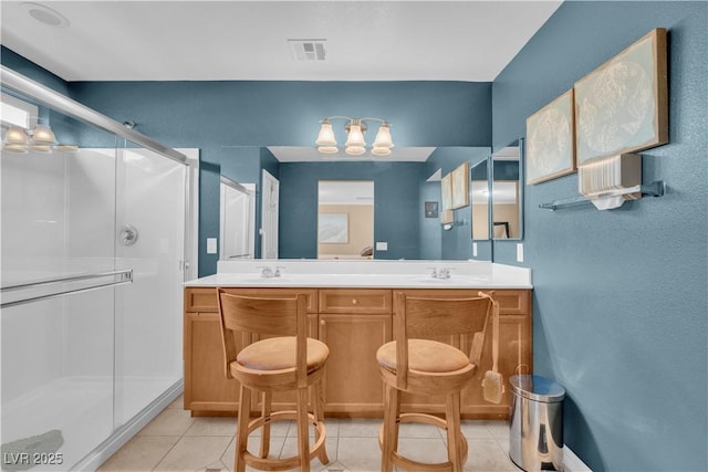 bathroom with double vanity, a chandelier, tile patterned flooring, a shower stall, and visible vents