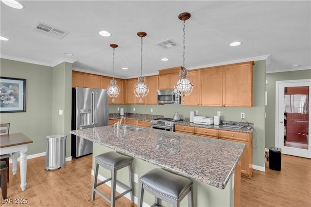 kitchen with a sink, visible vents, appliances with stainless steel finishes, and light wood finished floors