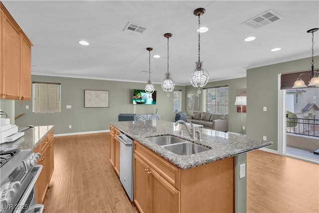 kitchen featuring open floor plan, light wood-style floors, visible vents, stainless steel appliances, and a sink