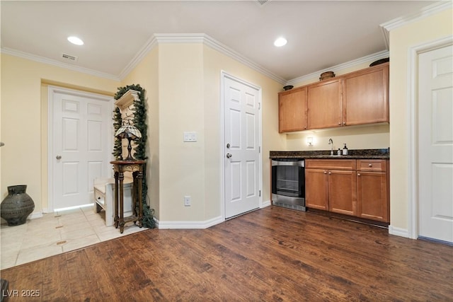 kitchen with visible vents, crown molding, baseboards, beverage cooler, and dark wood-style floors