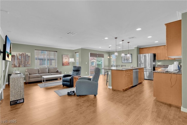 living room featuring ornamental molding, visible vents, light wood-style flooring, and recessed lighting