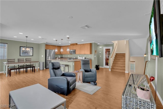 living room featuring light wood-style flooring, visible vents, recessed lighting, and stairs