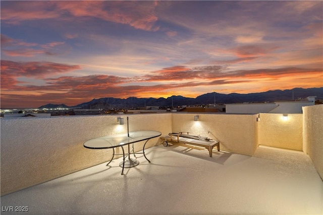 patio terrace at dusk with a balcony and a mountain view