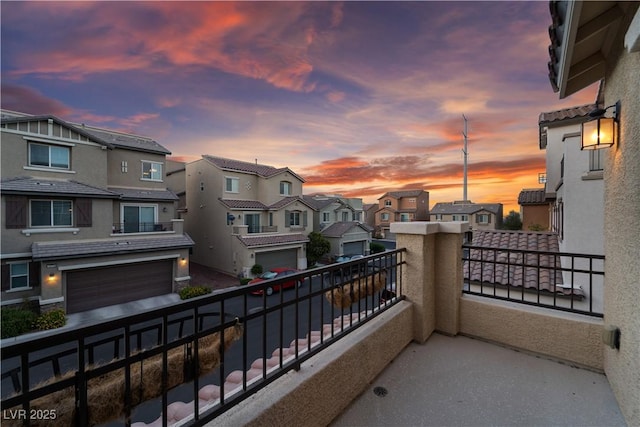 balcony at dusk featuring a residential view