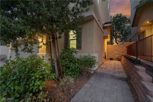 view of home's exterior with fence and stucco siding