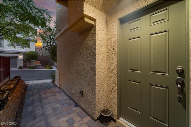 exterior entry at dusk featuring stucco siding