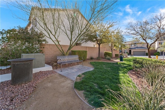 view of property's community with a lawn and fence